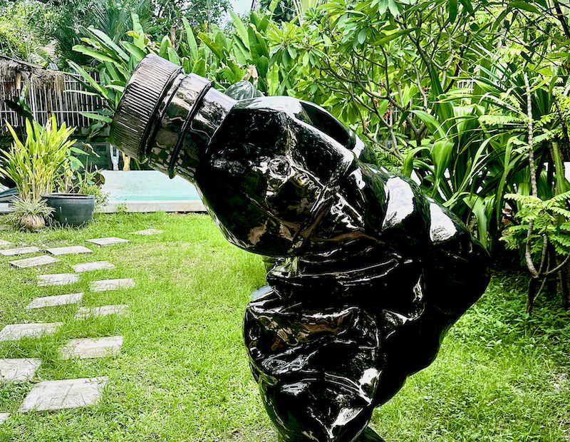 Sculpture H2O, 2026, by Bruno Tanquerel. Monumental dark chrome-plated brass sculpture resembling a compressed plastic bottle and suggesting a human form.
