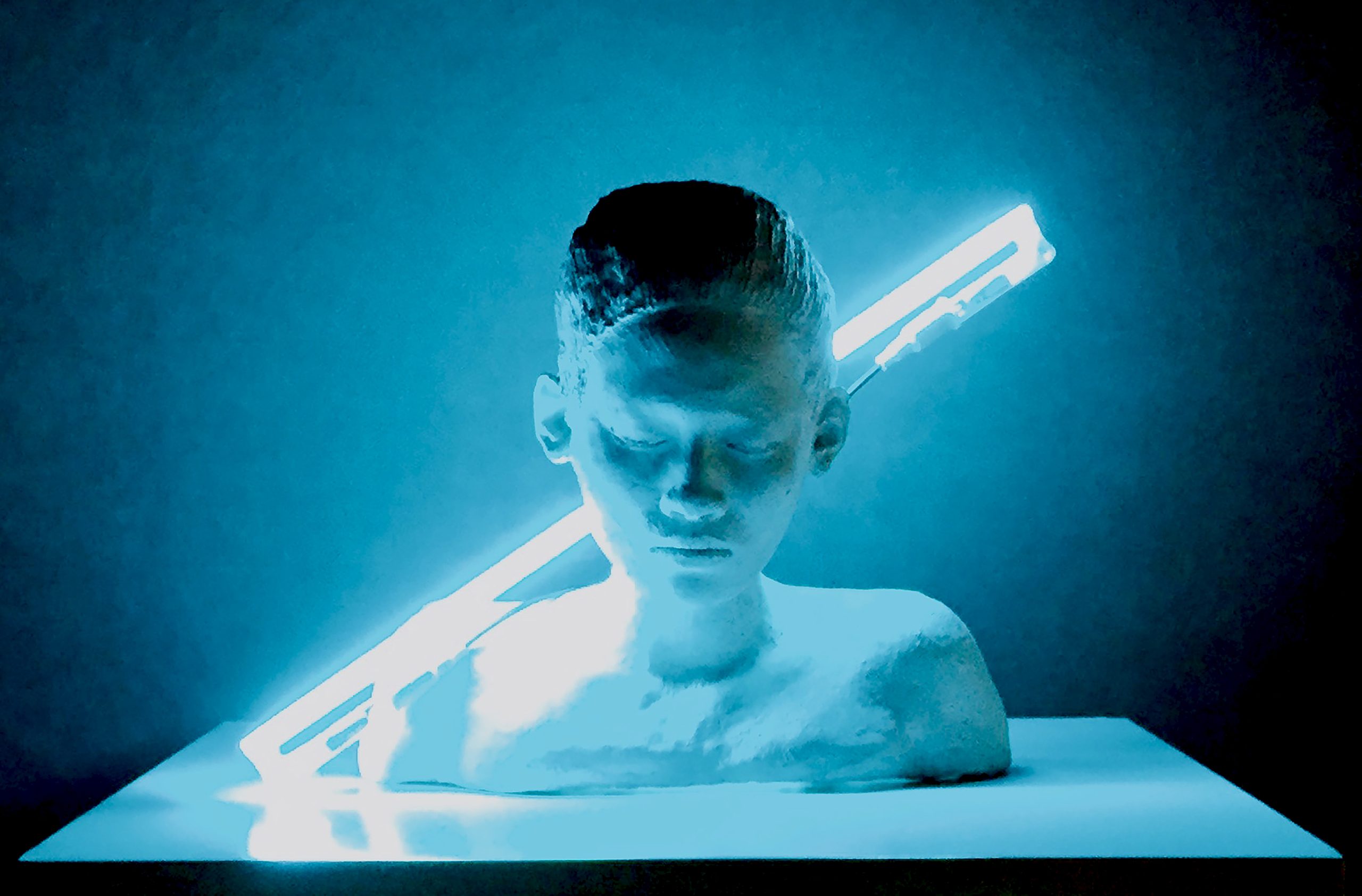 Introspection, 2015: ceramic bust with closed eyes and bowed head, lit by a diagonal blue neon tube.